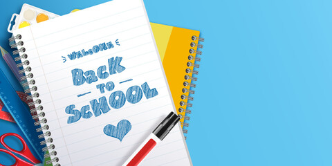 Welcome back to school text handwritten with marker on notebook with school supplies