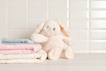 Set of baby towels, child organic hygiene and bunny toy in the bathroom