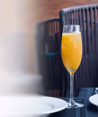A glass of orange freshly squeezed natural juice on a table in a restaurant. Proper nutrition. vertical composition.