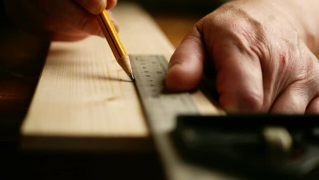 Carpenter using square to measure on wooden background