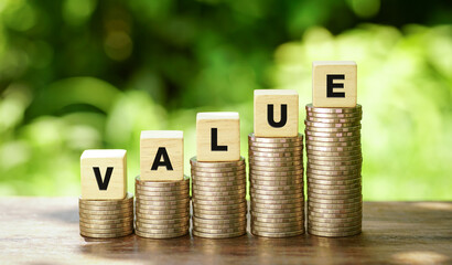 VALUE text written on wooden blocks on stack of coins stacked on natural background. business idea.                         
