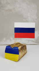 the Russian flag is stuck in the national dish of Ukraine lard. image of the Ukrainian flag on tallow