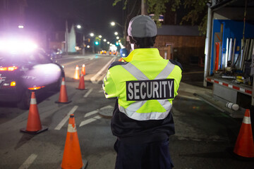 Security guard in car patroling at construction site at night  city
