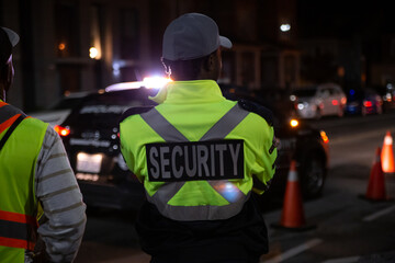 Security guard in car patroling at construction site at night  city