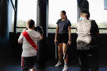 female kick boxing coach training children in gym