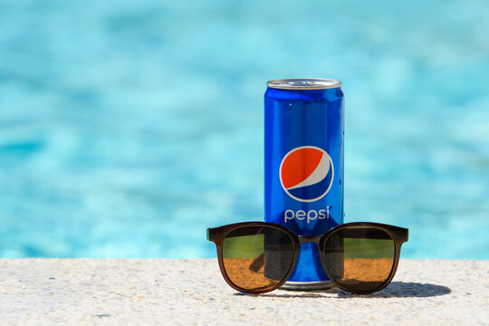 Novorossiysk - Russia, July 2022: Can of Pepsi Cola and sunglasses by the pool on a summer day.