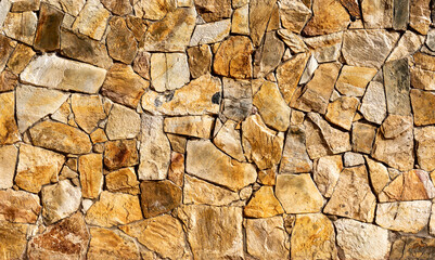 Texture of a varnished stone garden wall, with orange and yellow tones - Natural lighting -...