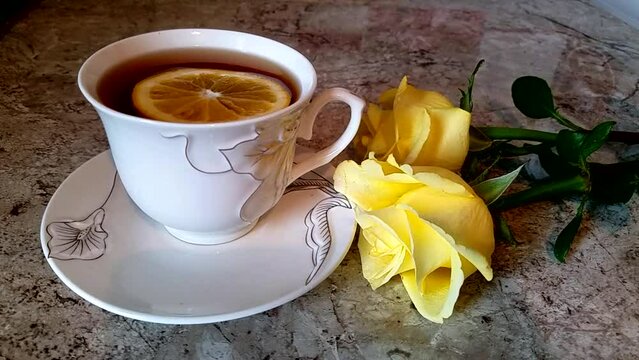 Three yellow roses and lemon tea