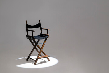 Directors chair stands in the beam of light. Space for text. The concept of selection and casting....