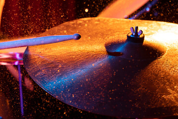 Dynamic scene. man playing the drum plate on a colored background, the concept of musical...