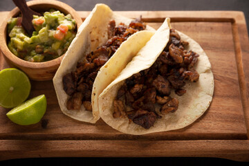 Tacos de Bistec. Homemade grilled meat in a corn tortilla. Street food from Mexico, traditionally accompanied with cilantro, onion and spicy sauce or guacamole