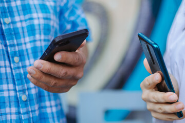 Dating on the street, a man and a woman exchanging phone numbers, two phones close-up