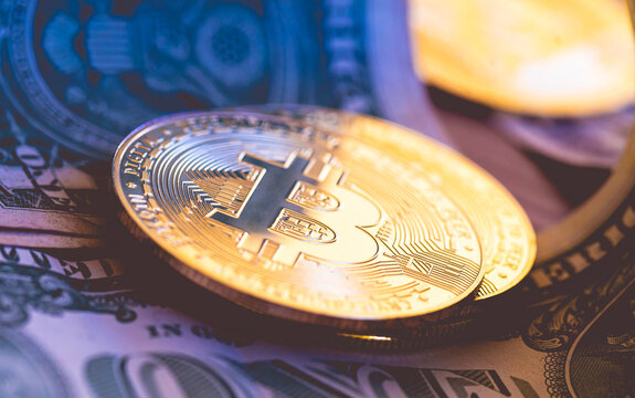 Bitcoin - BTC. Uma pilha de moedas de Bitcoins sobre cédulas de dólares americanos em fotografia macro. Conceitos de criptomoedas, finanças e risco.	
