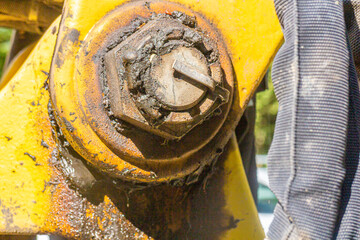 close up of a yellow joint on the arm of a shovel excavator with a lot of grease
