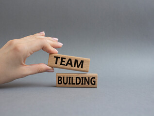 Team Building symbol. Concept word Team Building on wooden blocks. Beautiful grey background. Businessman hand. Business and Team Building concept. Copy space