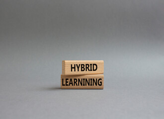 Hybrid learning symbol. Concept word Hybrid learning on wooden blocks. Beautiful grey background. Business and Hybrid learning concept. Copy space