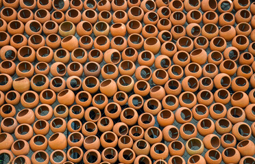 Texture or background of brown round clay pots on the wall