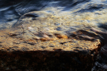 Small wave, stone and light reflection background - 520886928