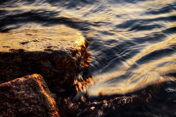 Small wave, stone and light reflection background - 520886929