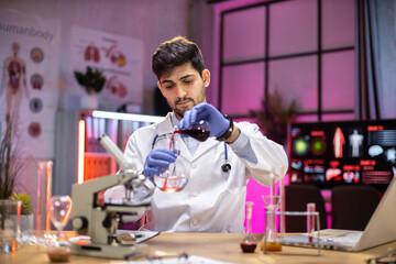 Male arab scientist working in modern lab. Doctor making microbiology research. Laboratory tools:...