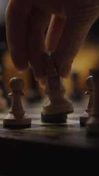 A young woman plays a chess game alone, close-up