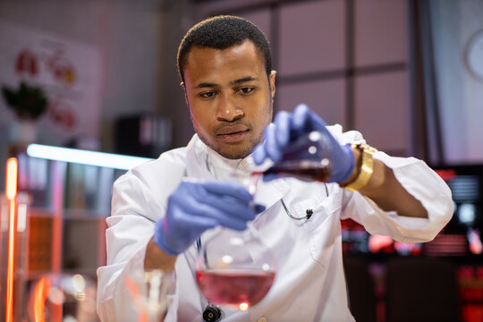 Experienced male scientist in health industry doing analysis of substance. Chemist researcher in sterile lab doing experiments for medical industry using modern technology.