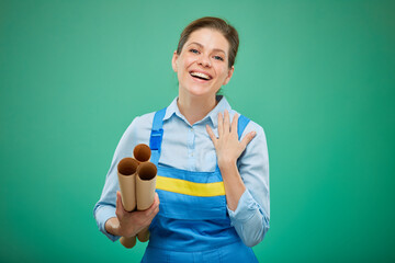Happy woman student in blue overalls holding blueprint. Isolated portrait on chromakey green...