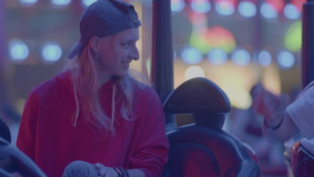 4k SlowMo - Young couple at the village fair, crashing cars. Boy flirting with her, they have a good time
