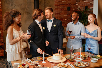 Portrait of young gay couple smiling happily while celebrating same sex marriage at wedding...