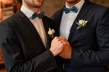 Close up of male gay couple holding hands during wedding ceremony, same sex marriage