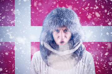 A citizen of Denmark freezes in front of the flag. Transition to renewable energy sources. Increase in the price of natural gas for home heating. Energy crisis in Europe.