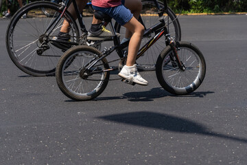 young man with customized bicycle shows off his style riding down the street on a sunny day.