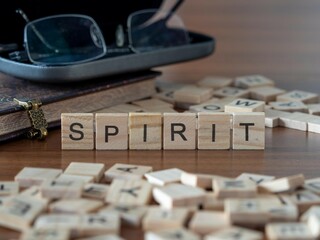 spirit word or concept represented by wooden letter tiles on a wooden table with glasses and a book - obrazy, fototapety, plakaty