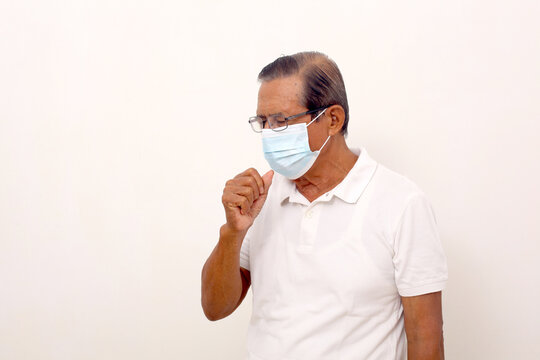 Elderly asian man wearing face mask standing while coughing. Isolated on white with copyspace