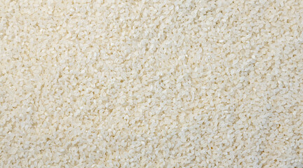 Texture of white uncooked rice. Rice background. Short grains of white round-grain rice.