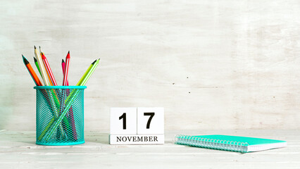 November 17 calendar. The concept of the date of the season. Pencils in a basket against the background of a notebook and the date of the month. Copy space calendar cube.