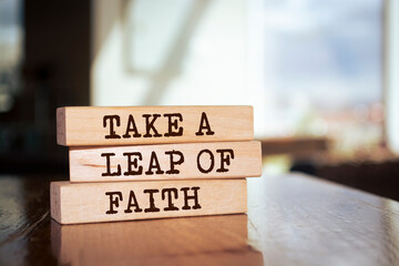 Wooden blocks with words 'TAKE A LEAP OF FAITH'.