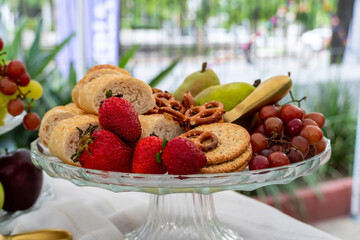 glass fruit basket, Picninc outside. out of focus vegetation in the background.