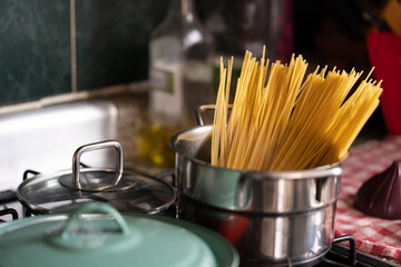 pasta espagueti cruda a punto de hervir en olla con agua hirviendo en cocina