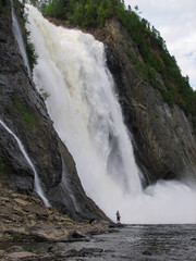 Quebec City, Canada - A person fishing at the base of Montmorency Falls (Chute-Montmorency in...