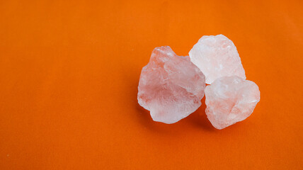 Isolated clear alum cubes on orange background concept for spa and body deodorant industrial