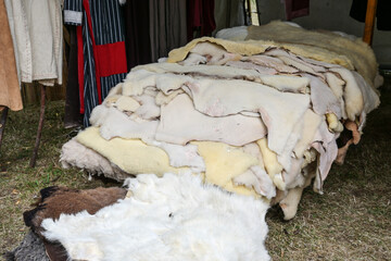 Heap of sheepskins for sale in a market stall at a medieval festival, selected focus