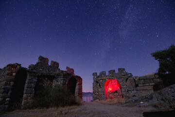 night view of the castle. A view of the stars of the Milky Way with a mountain top in the...