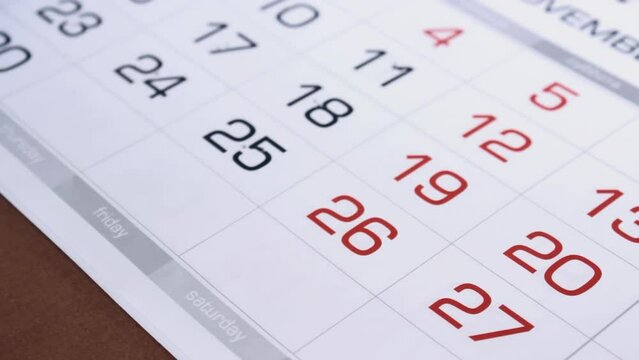 Time passing, calendar pages slowly turning measuring vanishing months, season changing. Indoor, nobody