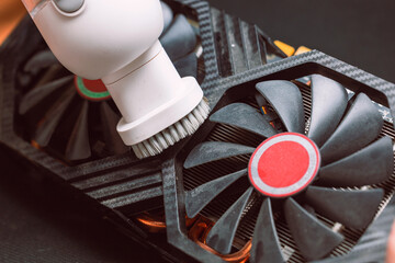 Computer master cleans the video card from dust with a vacuum cleaner