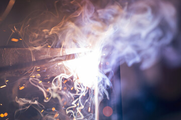 A bright flash of an electric arc between the electrode and the metal. arc welding