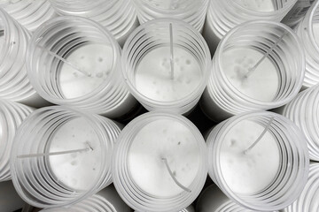 Many white candles in a plastic cup