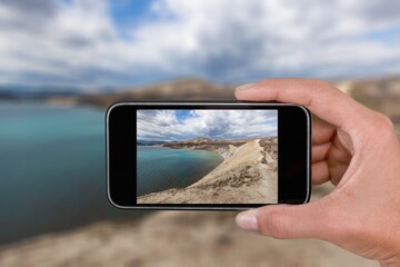 Taking photo on mobile phone of sea view, Photo Vacation time to the Sea, Hand on Mobile take Sea scape view.