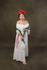 Full length female studio portrait of Mexican woman with scarf with the colors of the Mexican flag