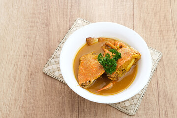 Kepiting Saus Padang (Crab with Padang Sauce), spicy and savory. Served in white bowl.
